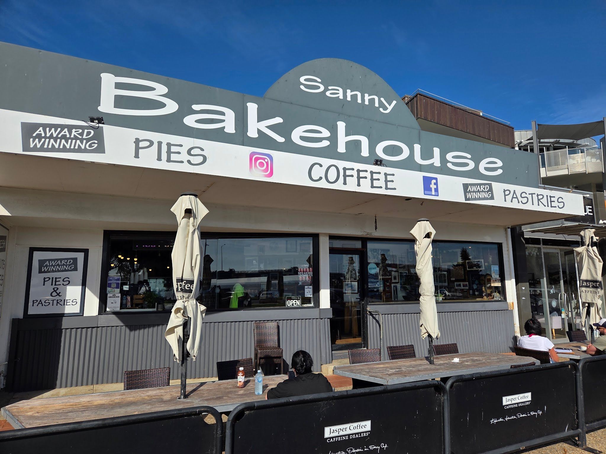 Sanny Bakehouse painted shopfront with award-winning pies and coffee signage and outdoor seating